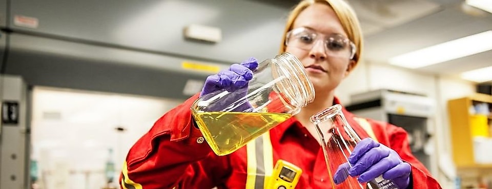 Laborantine en train de manipuler de l'huile dans un laboratoire