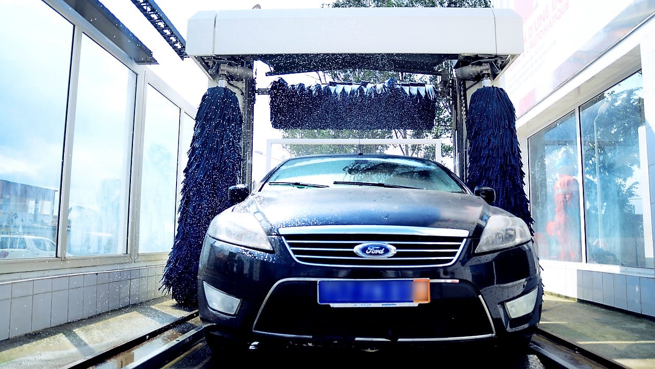 Belle voiture propre qui sort d'une baie de lavage Shell