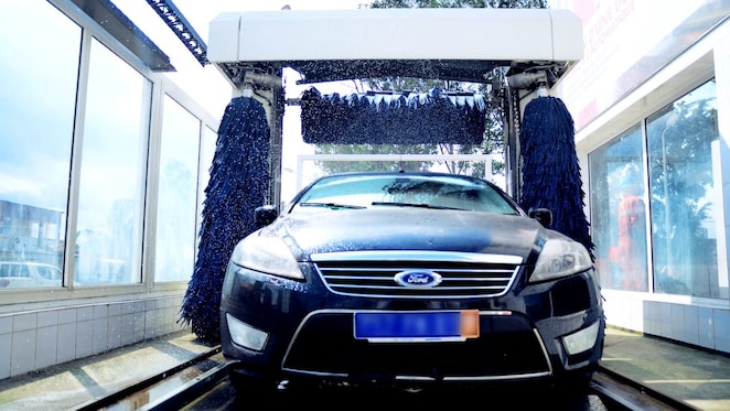 Belle voiture propre qui sort d'une baie de lavage Shell