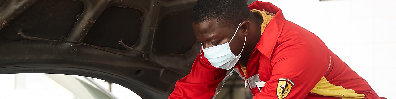 Technicien Shell effectuant une vidange moteur avec professionnalisme en station-service