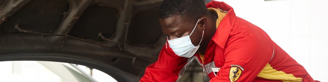 Technicien Shell effectuant une vidange moteur avec professionnalisme en station-service
