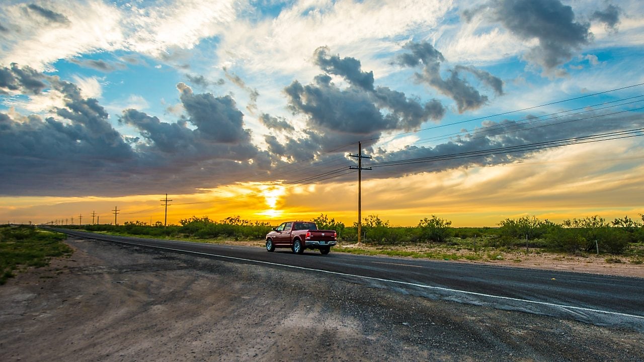 Voiture roulant vers le soleil couchant