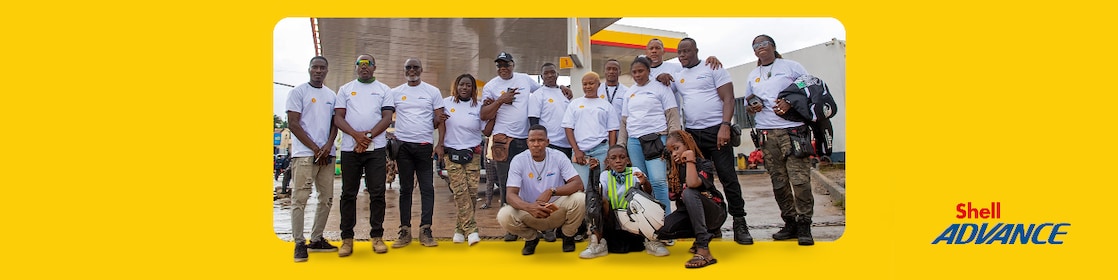 Équipe de motards du Camping Moto Tour Ivoire 2025 devant une station Shell, partenaires de l’événement avec Shell Advance.