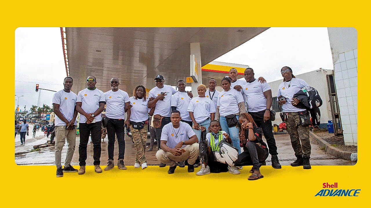 Équipe de motards du Camping Moto Tour Ivoire 2025 devant une station Shell, partenaires de l’événement avec Shell Advance.