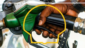 main tenant une pompe à carburant et injectant du carburant dans un réservoir de voiture